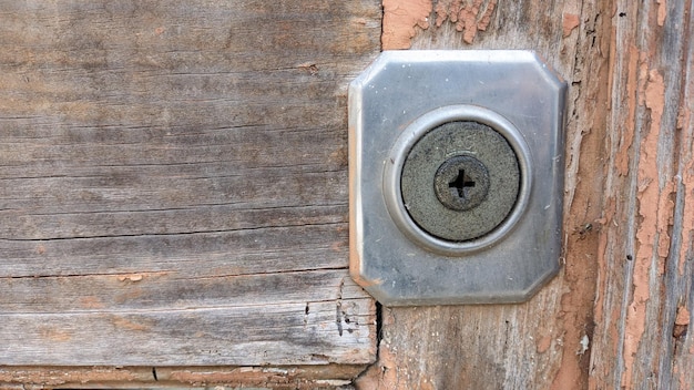 En una casa abandonada en una puerta vieja de la que ya se ha caído la pintura vieja un viejo metal oxidado