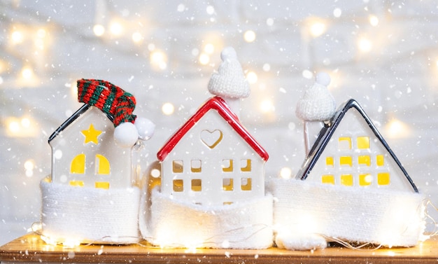 La casa acogedora está envuelta en un sombrero y una bufanda en una decoración de alféizar de ventana de tormenta de nieve Protección de aislamiento del hogar de nieve de invierno contra el frío y el mal tiempo sistema de calefacción Ambiente festivo Navidad Año Nuevo