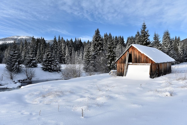 Casa alpina cubierta de nieve en las montañas en invierno