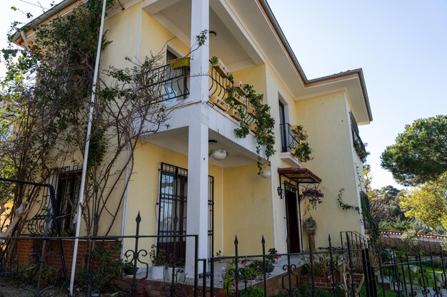 Una casa amarilla con un borde blanco y una valla blanca