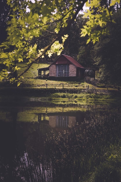 Foto casa ao lado do lago contra as árvores