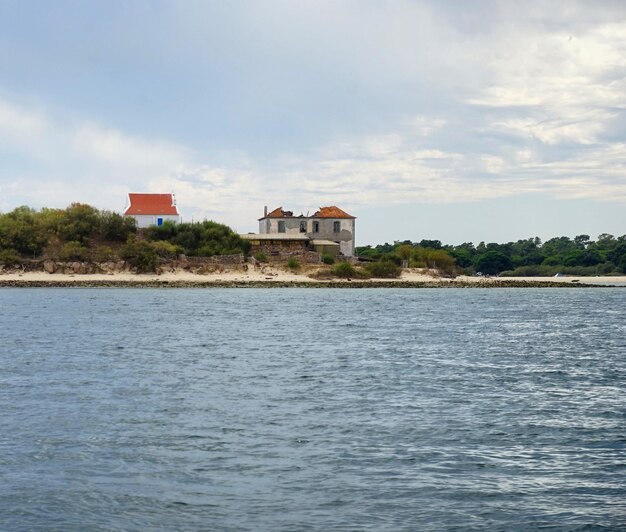 Foto casa ao lado do mar contra o céu