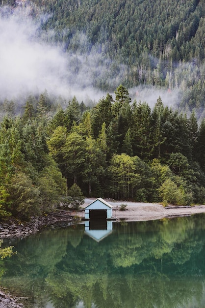 Casa de barco desierta junto a un lago con niebla matinal