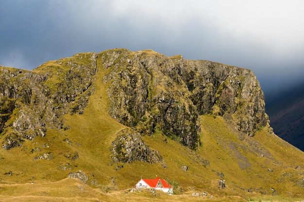 Casa de campo en la base del acantilado de roca este de Islandia