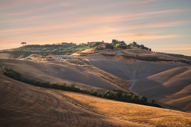 Casa de campo típica en lo alto de una colina en Val d'Orcia. Paisaje paisaje al atardecer de la Toscana en Italia