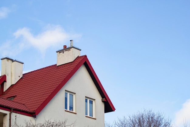 Una casa con chimenea y un cielo azul.