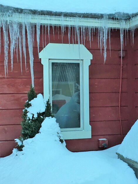 Casa coberta de neve contra o edifício