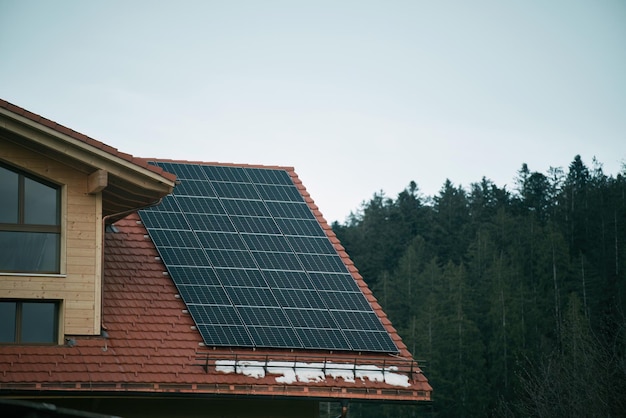 Casa com painéis solares Painéis fotovoltaicos PV no fundo do céu Painéis solares azuis Uma fonte alternativa de eletricidade