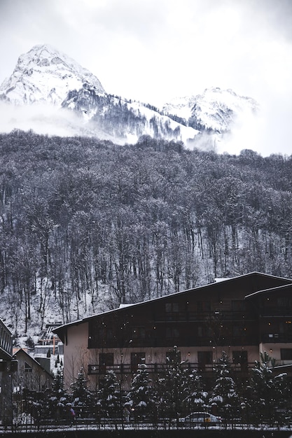 Casa contra altas montanhas na neve