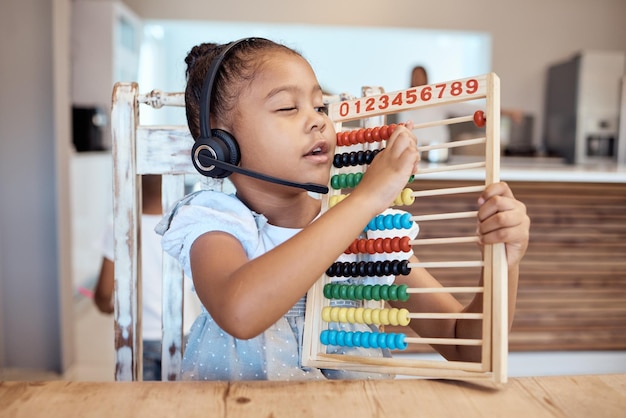 Casa de educação e criança aprendendo matemática com um brinquedo colorido de desenvolvimento infantil para contagem de números Fones de ouvido matemática ou jovem estudante criativo do jardim de infância estudando em casa ocupado com avaliação