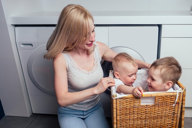 Casa de família feliz fim de semana máquina de lavar banheiro mãe e filho pequeno na lavanderia lavadora de roupas lavadas