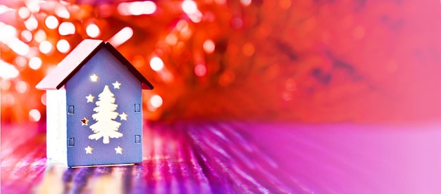 Casa de madeira com janelas luminosas em forma de árvore de Natal fundo desfocado bandeira vermelha bokeh