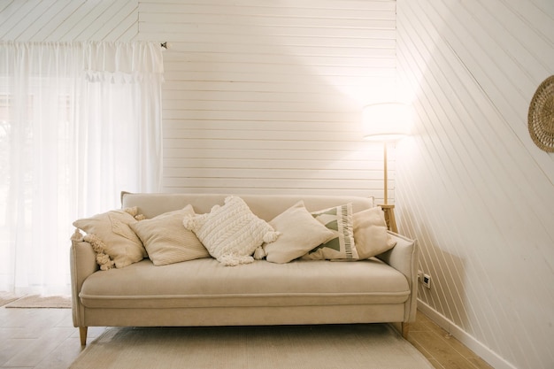Casa de madeira moderna Belo interior de estilo escandinavo boho com um sofá leve e almofadas com franjas