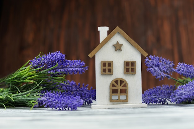 Casa de madeira um brinquedo branco acolhedor com flores