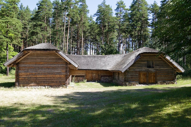 Casa de madeira velha tradicional com telhado de junco na Letônia