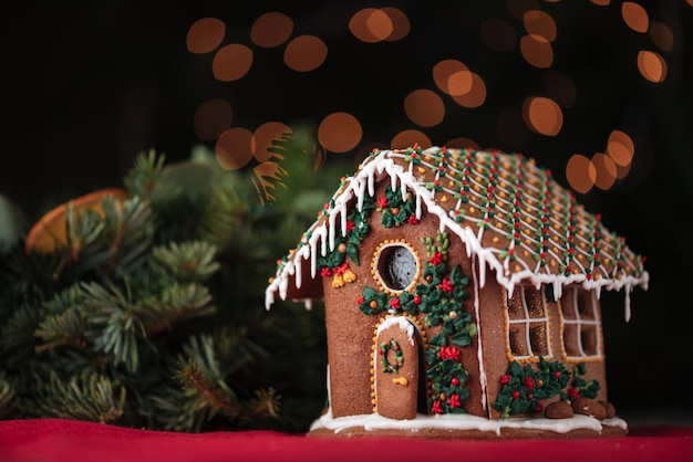 Casa de pão de mel e árvore de Natal sobre parede brilhante