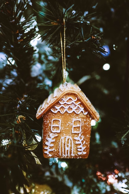 Casa de pão de mel pendurada na árvore de Natal