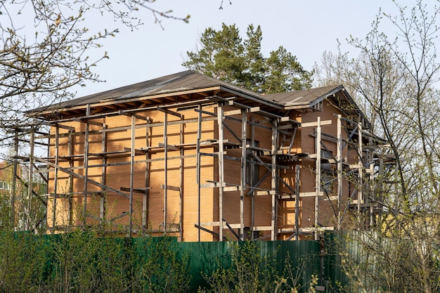 Casa de tijolo inacabada com andaime de madeira apresentado