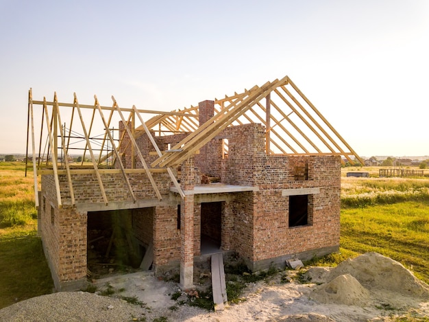 Casa de tijolos inacabada com estrutura de telhado de madeira em construção