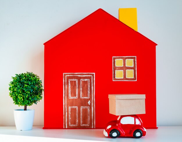 Casa decorativa vermelha com carro de brinquedo