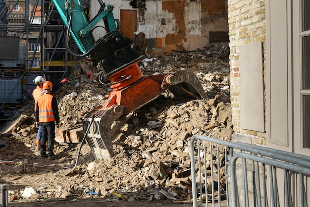 Casa destruida en ruinas Una excavadora destruye una casa con un balde