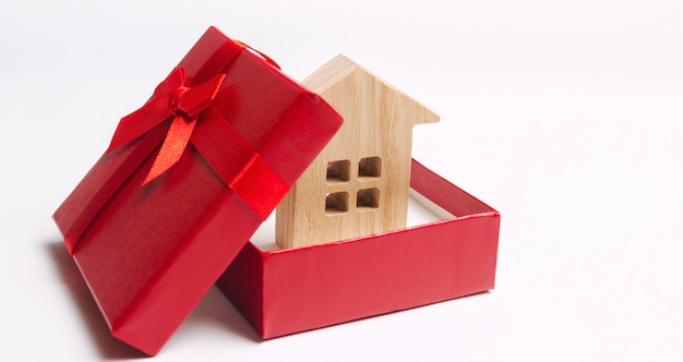 Casa diminuta de madeira em uma caixa de presente. Habitação como um presente. Ganhe um apartamento na loteria.