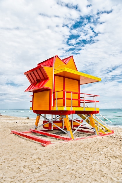 Casa do salva-vidas na praia de areia em miami, eua. torre para resgate baywatch em típico estilo art déco. casa de madeira na costa do oceano em céu nublado. conceito de férias de verão. proteção e segurança pública