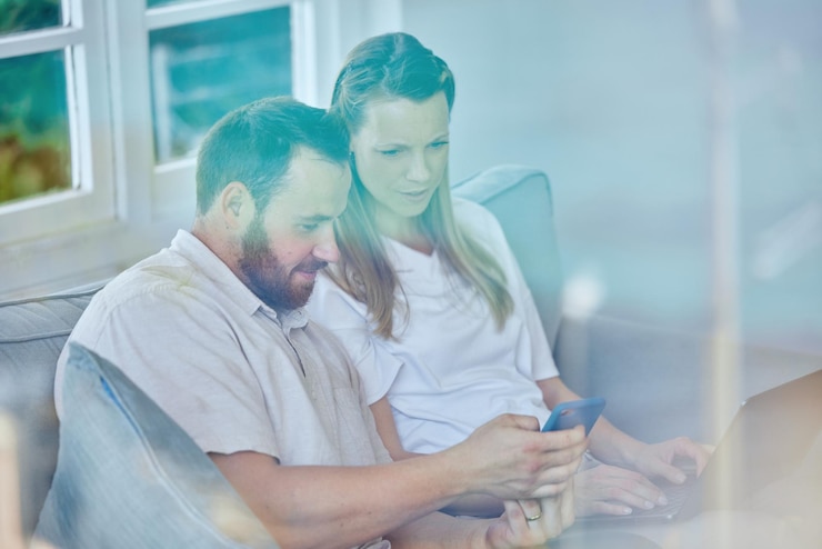 Foto casa e casal relaxando no sofá smartphone e digitando com conexão de mídia social e mensagens de texto apartamento homem ou mulher no sofá usuário móvel ou celular com mensagem contato ou informações de site