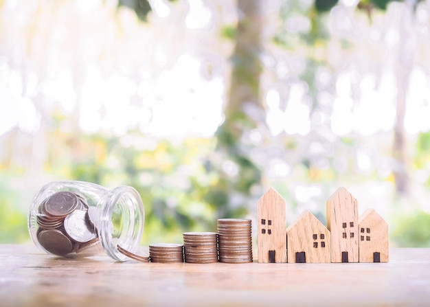 Casa em miniatura com pilha de moedas para o conceito de propriedade de investimento Economizando dinheiro para comprar uma casa