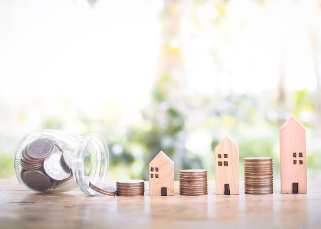 Casa em miniatura com pilha de moedas para o conceito de propriedade de investimento Economizando dinheiro para comprar uma casa