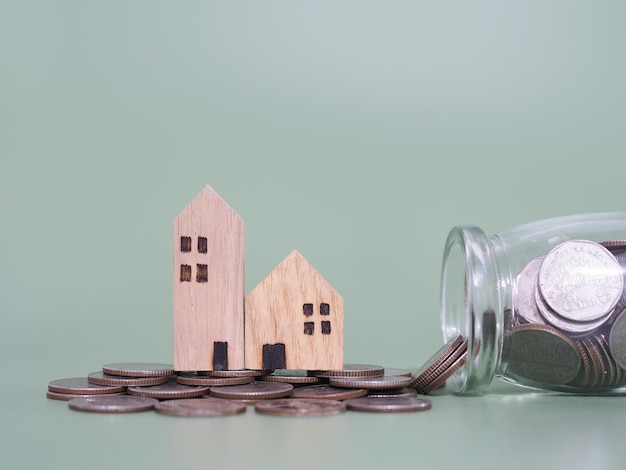 Casa em miniatura e pilha de moedas O conceito de poupar dinheiro para casa Investimento imobiliário Hipoteca de casa Imóvel