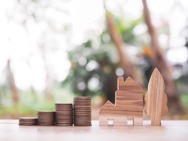 Foto casa em miniatura e pilha de moedas o conceito de poupar dinheiro para casa investimento imobiliário hipoteca de casa imóvel