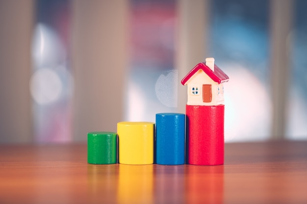 Foto casa em miniatura em um bloco de madeira colorido usando como propriedade imobiliária e conceito familiar