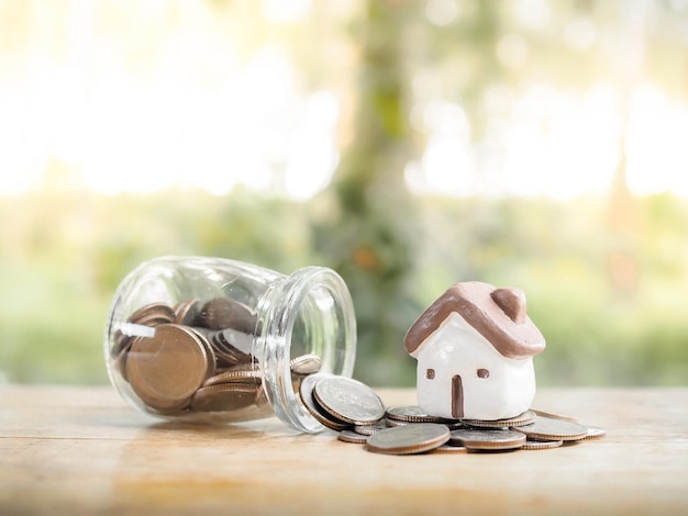 Casa em miniatura na pilha de moedas para o conceito de propriedade de investimento. Economizando dinheiro para comprar uma casa.
