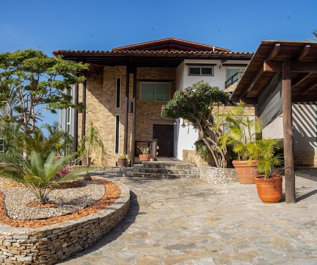 una casa con una escalera de piedra y una palmera en el lado derecho