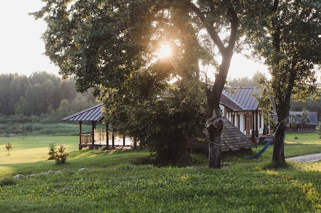 Casa europea de madera en un pintoresco paisaje al atardecer en verano