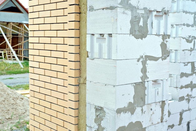 Casa feita de concreto de espuma isolada com lã mineral e forrada com tijolos