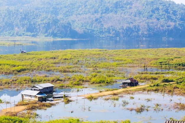 Casa flotante en el río Songgaria y cerca de la montaña en el campo de la aldea en Snagklaburi, Tailandia