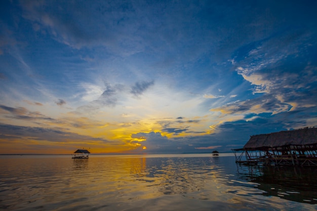 Casa flotante en el terraplén con fondo del atardecer