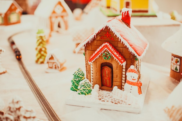 Casa de galletas de jengibre en el pueblo navideño en la feria. Postre de aroma tradicional de vacaciones con miel y especias.