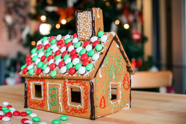 Casa de hadas de pan de jengibre con brillante árbol de Navidad con guirnalda