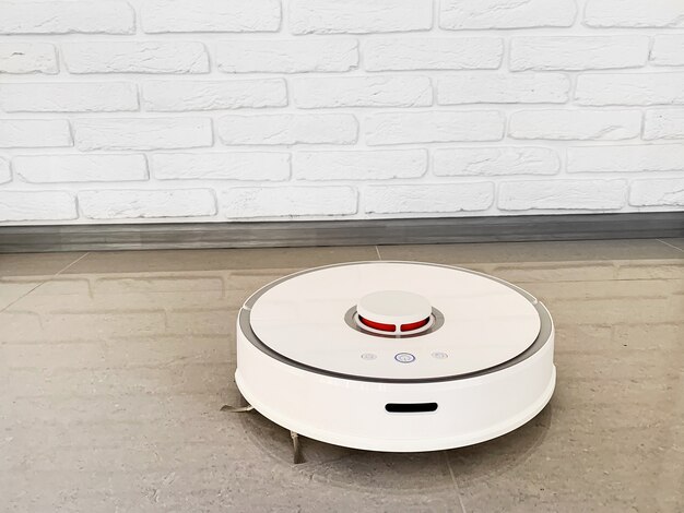 Casa inteligente. El robot aspirador funciona en el piso de una sala de estar.