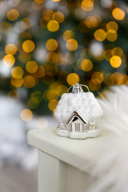 Foto casa de juguete de cristal de navidad en la nieve, con el telón de fondo del bokeh de las luces de la guirnalda
