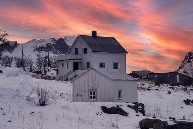 Casa de madera y almacén en la colina de nieve por la noche en las islas Nordland Lofoten