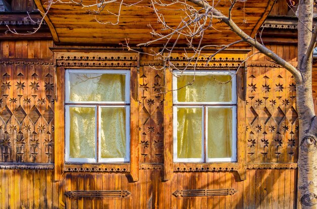 Una casa de madera con un árbol al frente.