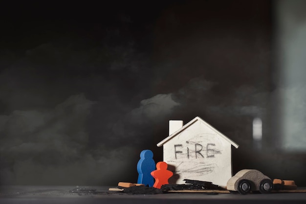 Casa de madera estatuillas coloridas ladrillos rojos y un auto con las consecuencias del incendio en el hogar