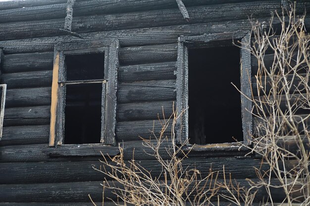 Casa de madera tras el incendio. Carbones en los troncos. Las cenizas de la casa del fuego. Cabaña destruida quemada.