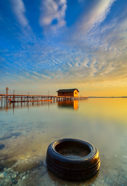 casa de madera en el mar en una hermosa puesta de sol