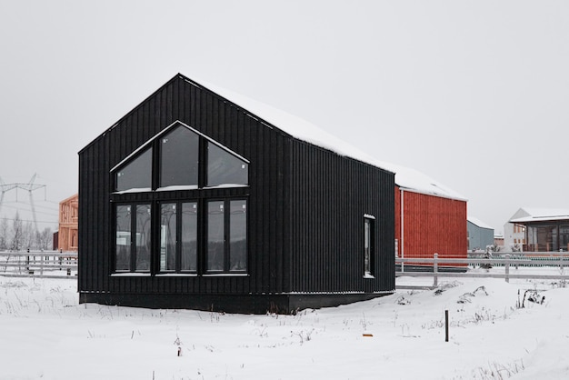 Casa de madera moderna al estilo escandinavo con un día de invierno de diferentes colores en el pueblo