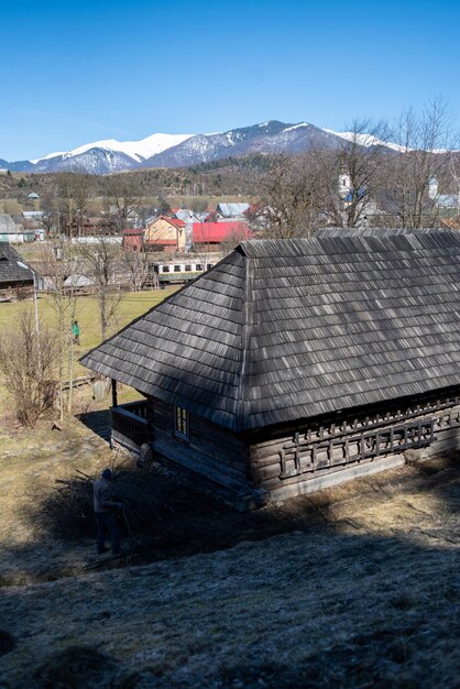 Una casa de madera con una montaña al fondo